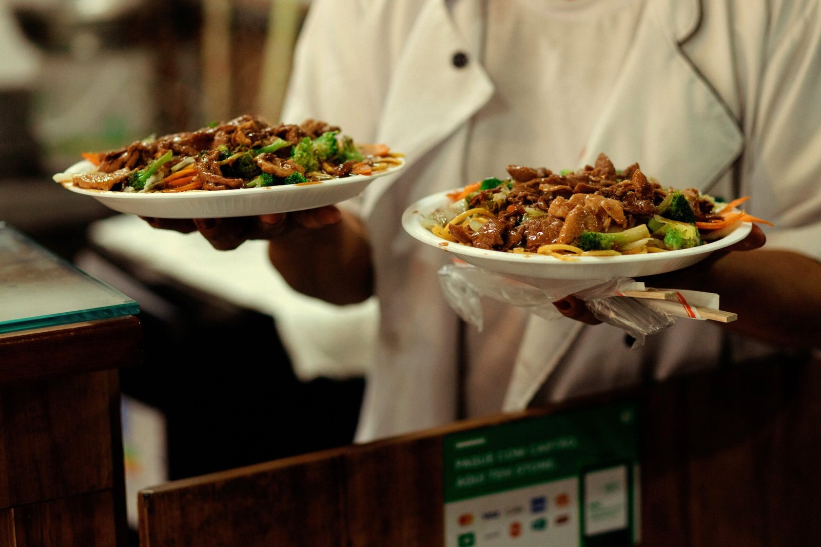 Garçom levando dois pratos de refeição em um restaurante